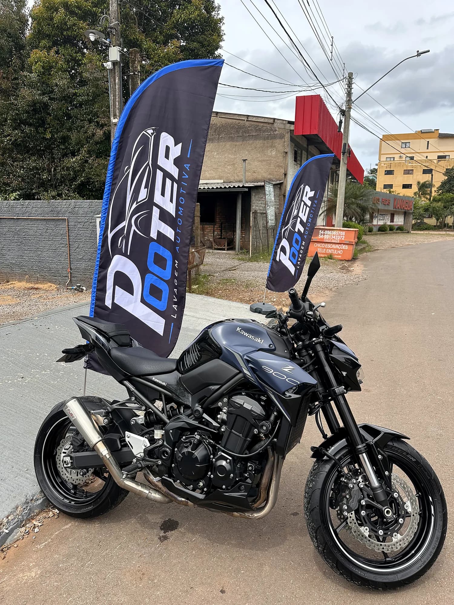 Kawasaki Z900 preta limpa entre os wind banners da Pooter Lavagem Automotiva em Marau-RS